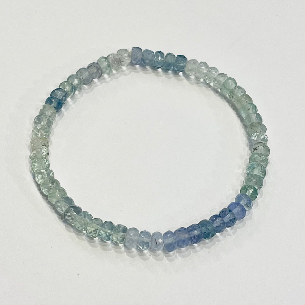 Beaded bracelet with blue and green stones on a white background