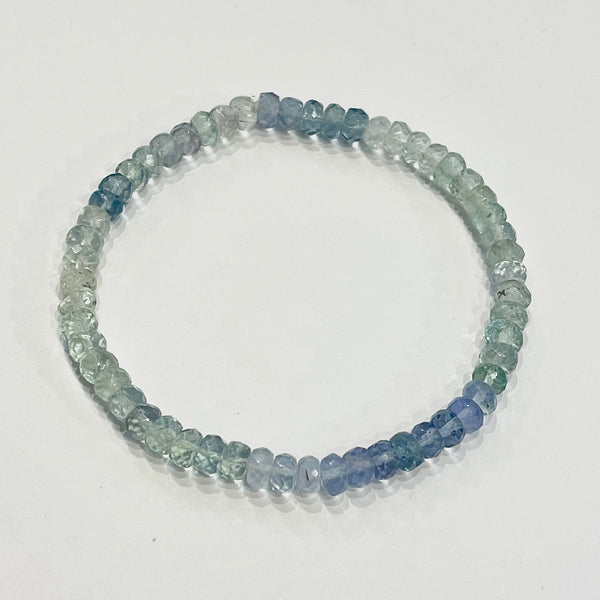 Beaded bracelet with blue and green stones on a white background