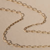 Gold chain necklace on a beige background