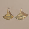 Pair of gold earrings on a beige background