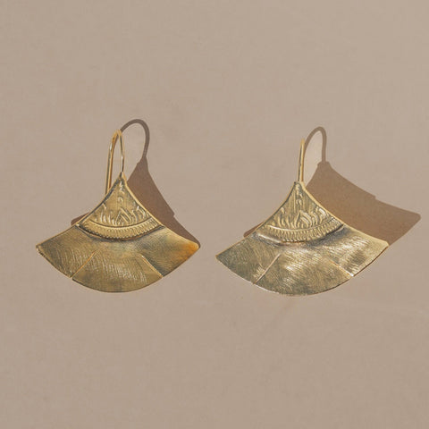 Pair of gold earrings on a beige background
