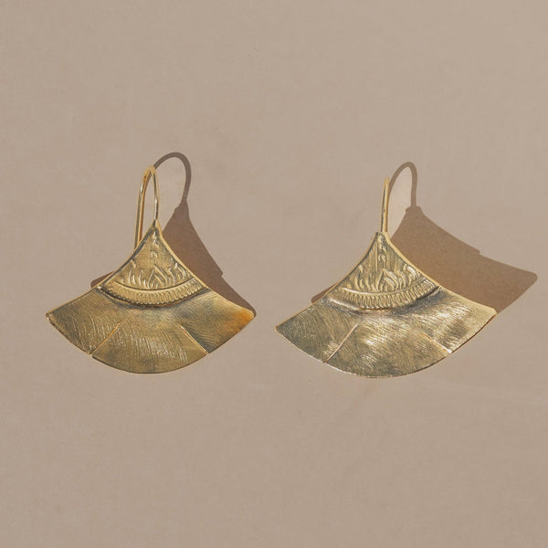 Pair of gold earrings on a beige background