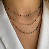 Multicolored beaded necklace on a person wearing a white garment