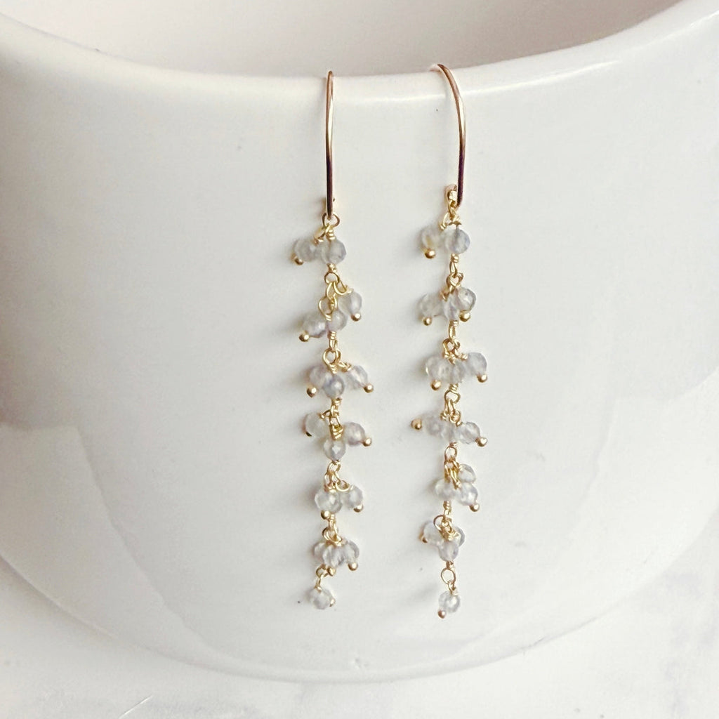 Gold earrings with small beads on a white background