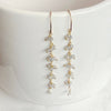 Gold earrings with small beads on a white background