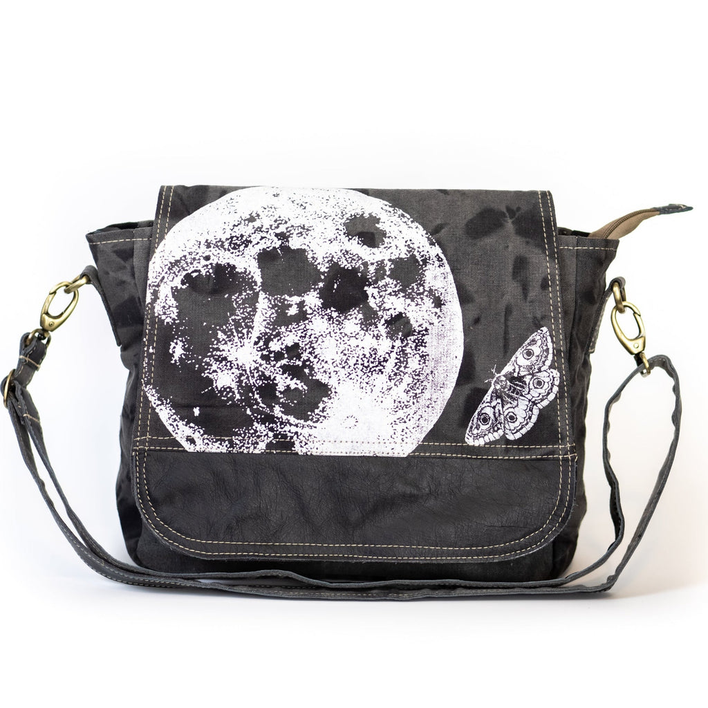 Black bag with white moon and butterfly design on a white background