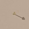 Tiny gold vermeil stud earring consisting of three beads formed into a triangle. 