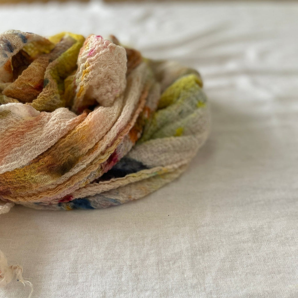 Colorful knotted scarf on a white surface