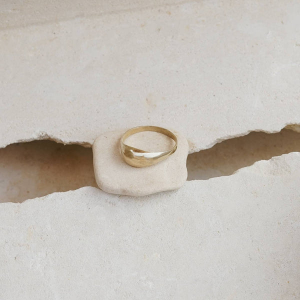 Gold ring on a white stone surface