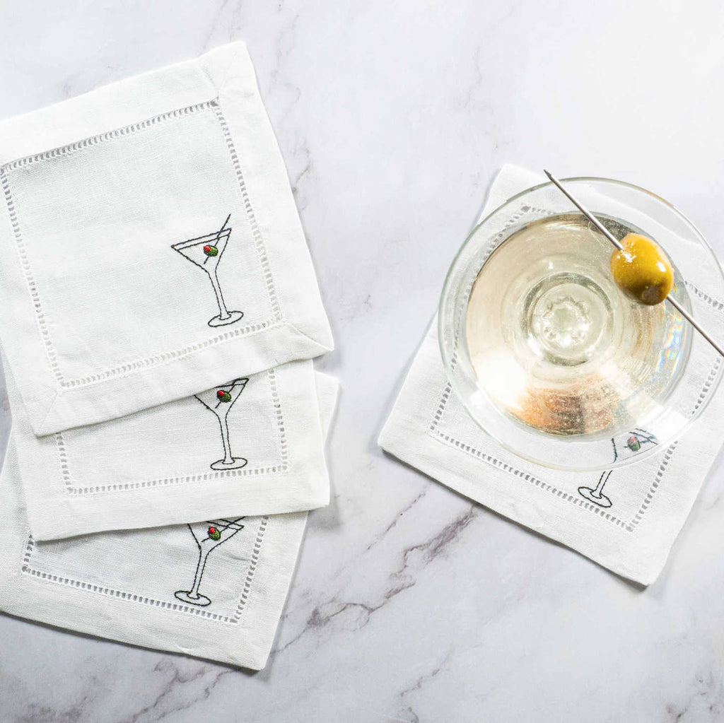 White cocktail napkins with martini glass design on a marble surface