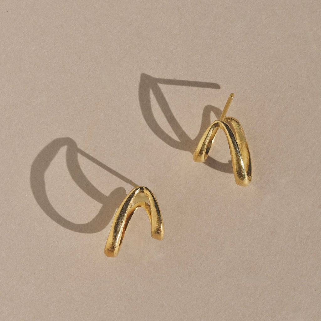 Gold hoop earrings on a beige background