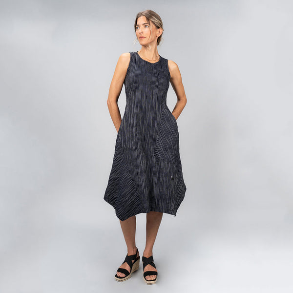 Model wearing navy blue and white striped flared dress with an angled skirt edge.