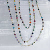 Multicolored beaded necklace on a textured white surface