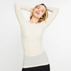 Woman wearing a beige long-sleeve top against a white background