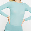 Woman wearing a light blue long-sleeve top against a white background