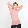 Woman wearing a pink long-sleeve top on a white background