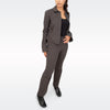 A woman modeling a dark brown tailored two-piece suit consisting of a button-up jacket and matching trousers, worn over a black top and black shoes, against a light gray studio background.