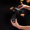 Person holding a black Noshkinu refill bottle and packaging against a dark background with orange slices.