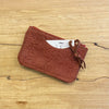 Brown textured cardholder on a wooden surface
