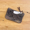 Brown leather pouch with a textured surface on a wooden background