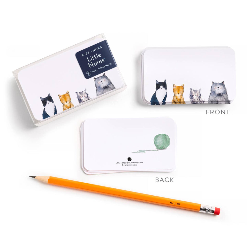 Notebook with cat illustrations, pencil, and box on a white background