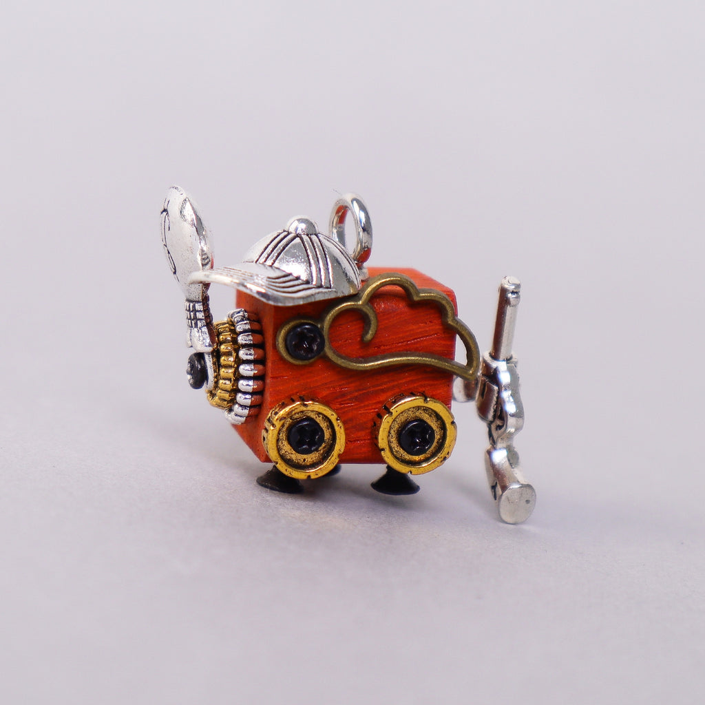 Small wooden figurine with metallic accents on a light gray background