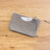 Gray textured pouch on a wooden surface