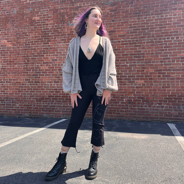 Girl wearing black tanktop, open gray cardigan and black ankle pants