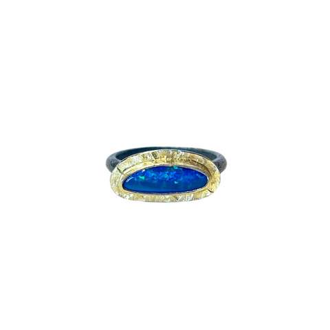 Blue green organically oval Australian opal with a gold bimetal bezel and textured border, and an oxidized silver band.
