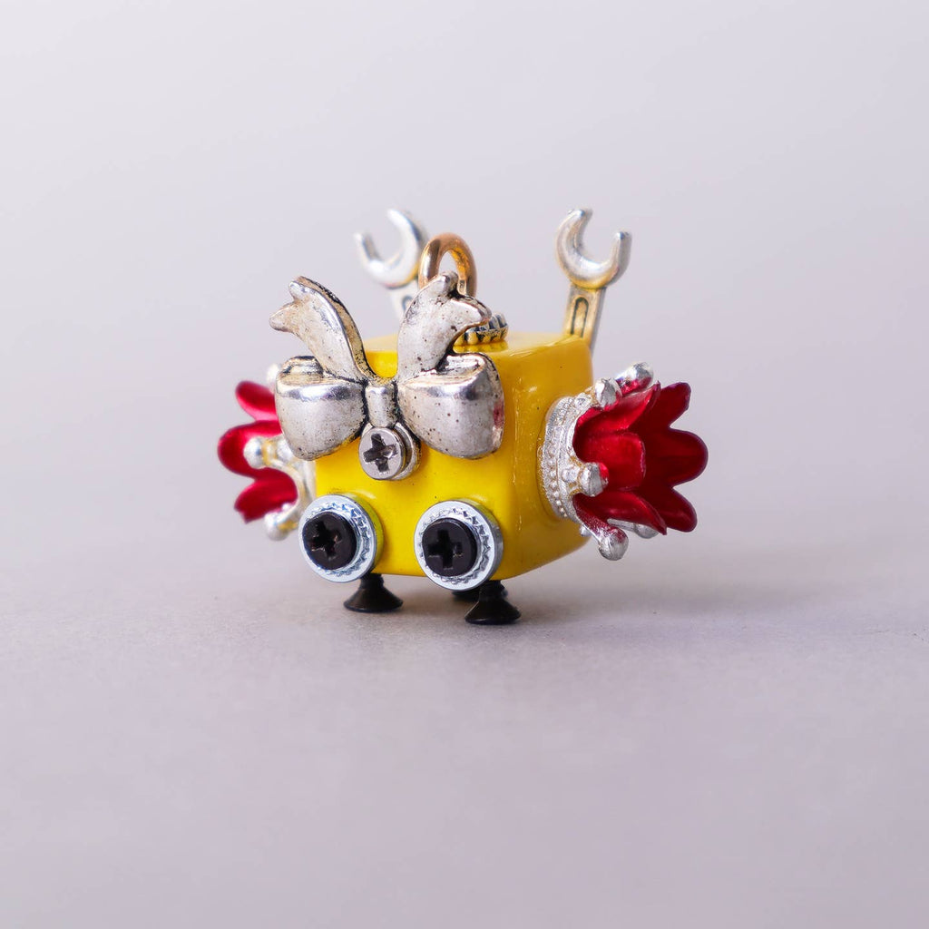 Colorful keychain with a yellow base, red accents, and silver details on a light gray background