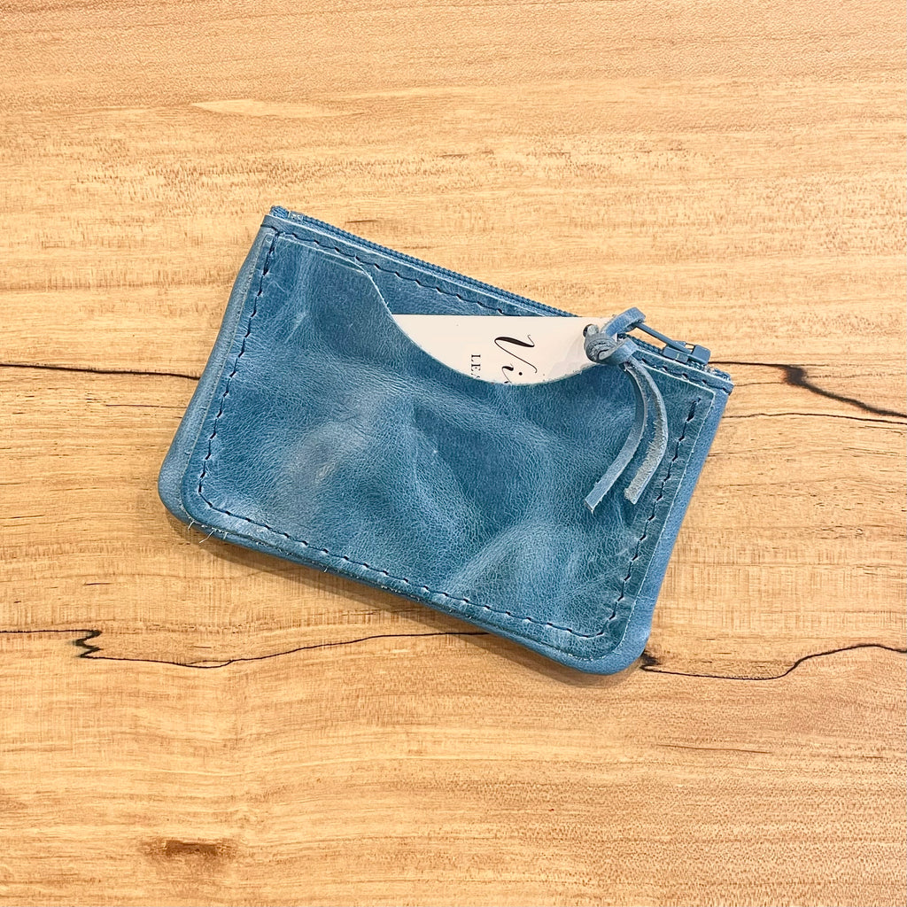 Blue leather cardholder on a wooden surface