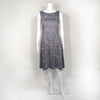 Mannequin wearing cool gray flare spring dress patterned with light yellow lines going horizontal and diagonal. 