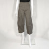 Mannequin wearing grey green cargo-like pants with a cropped and barrel-leg legs. It includes a front zipper.