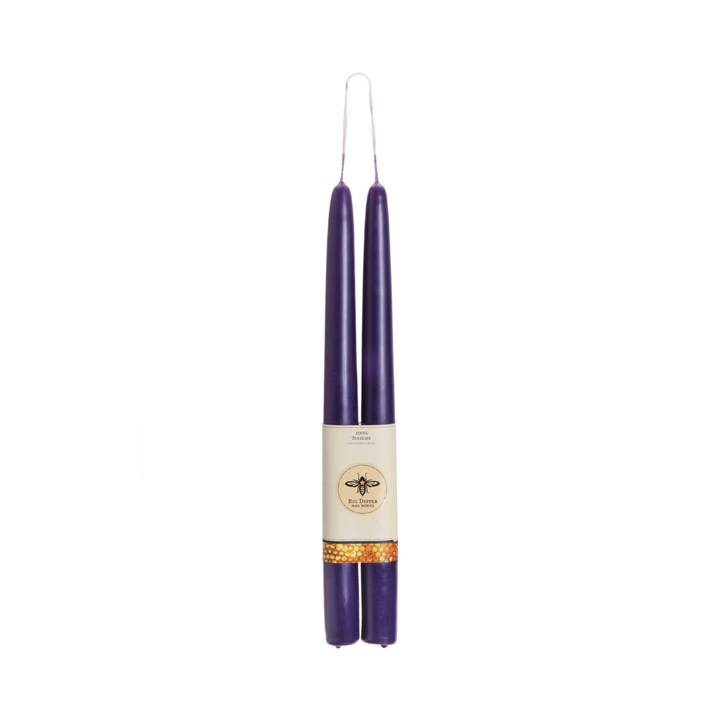 Two purple candles with a label on a white background