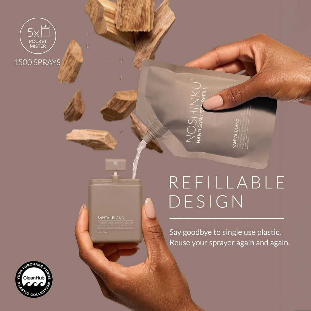 A hand holds an open perfume bottle while another hand pours liquid from a Noshinku refill pouch into it. Floating wood chips and text reading 'REFILLABLE DESIGN' and '1500 SPRAYS' appear on a muted mauve background.