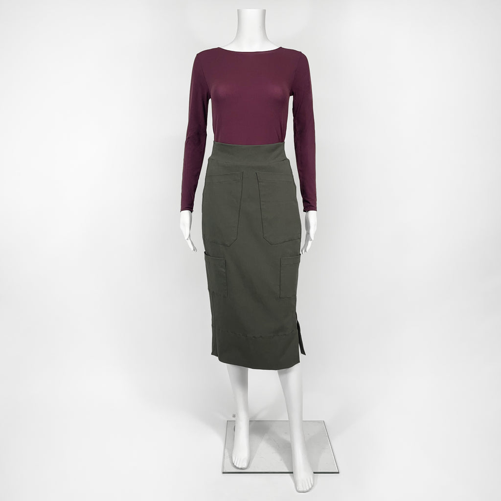 Mannequin wearing a maroon long-sleeve top and green skirt on a white background