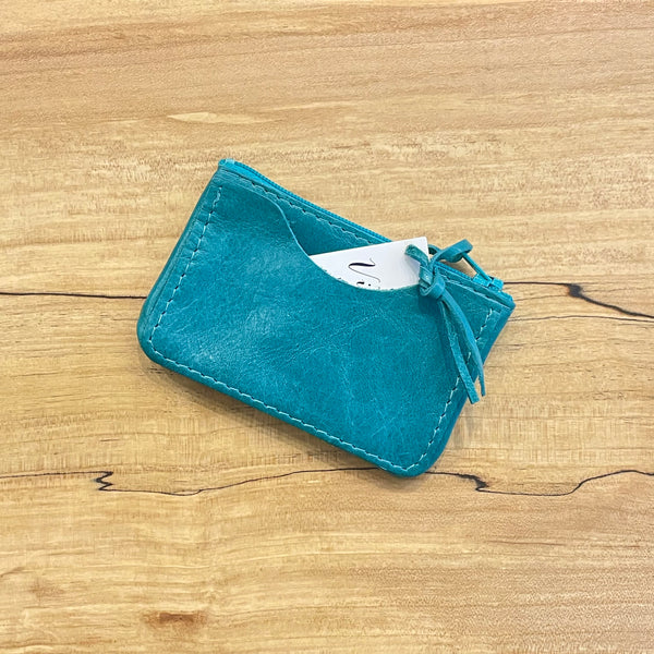 Blue leather cardholder on a wooden surface