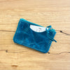 Blue leather cardholder on a wooden surface