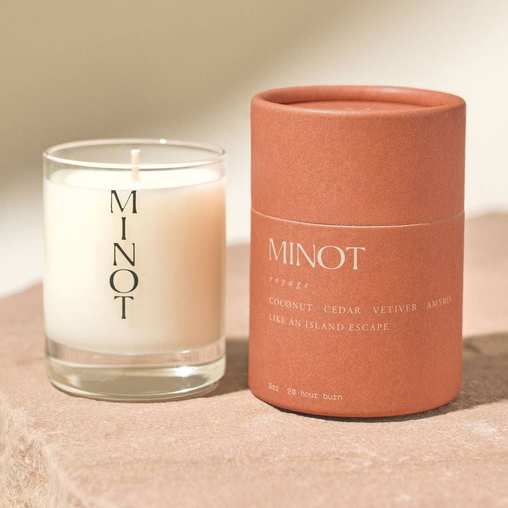 Minot candle and its packaging on a beige surface