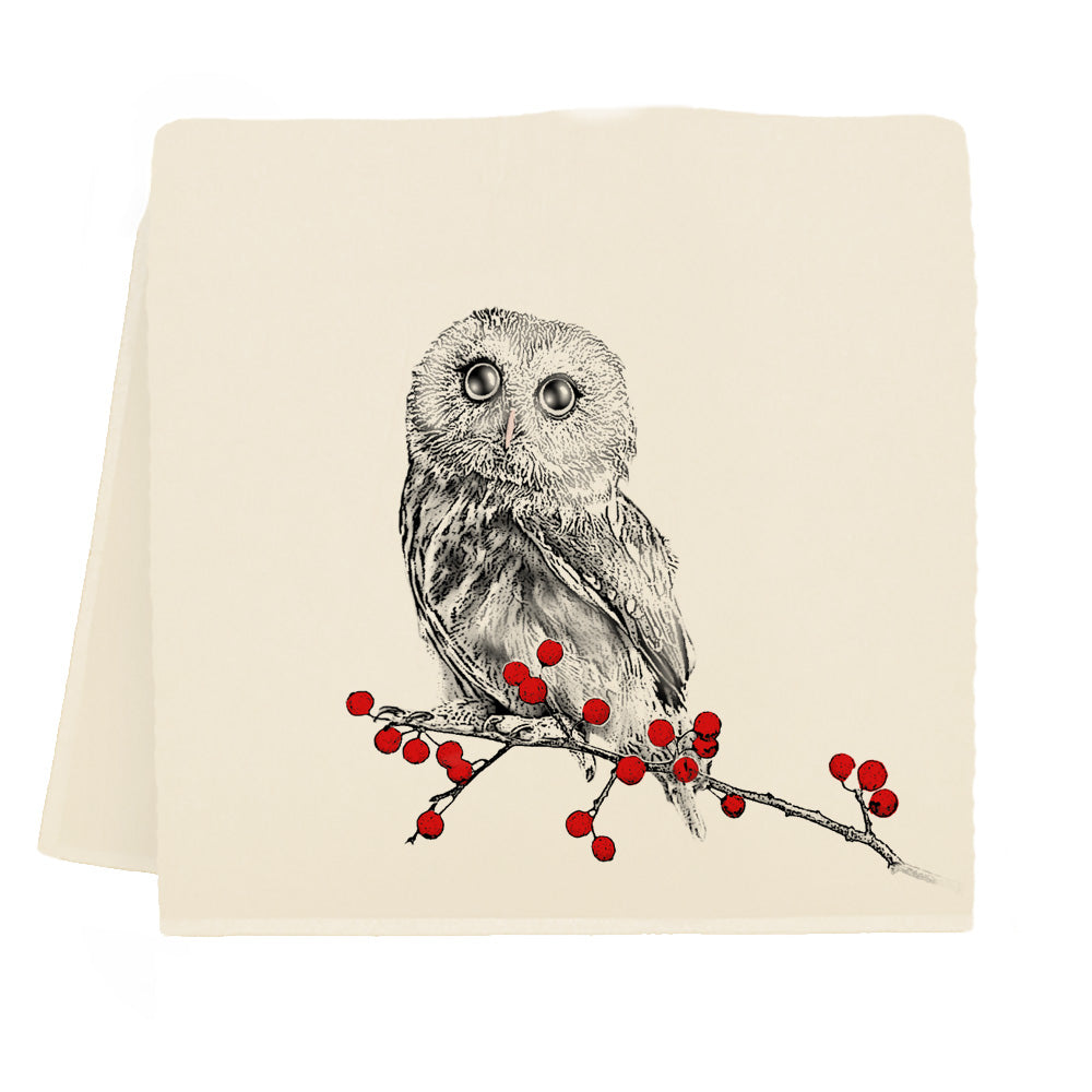 Owl on a branch with red berries on a folded beige fabric background