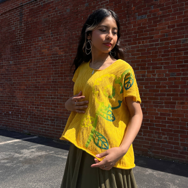 Girl wearing yellow cardigan with flower detail going down left side