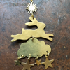 Brass-colored leaping rabbit, cloud, and star earrings on a wooden surface