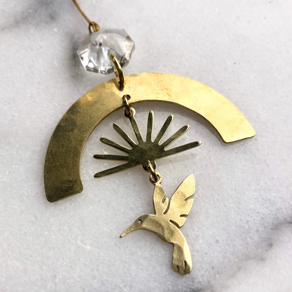 Brass ornament with crystal, rainbow, sunset and bird in flight