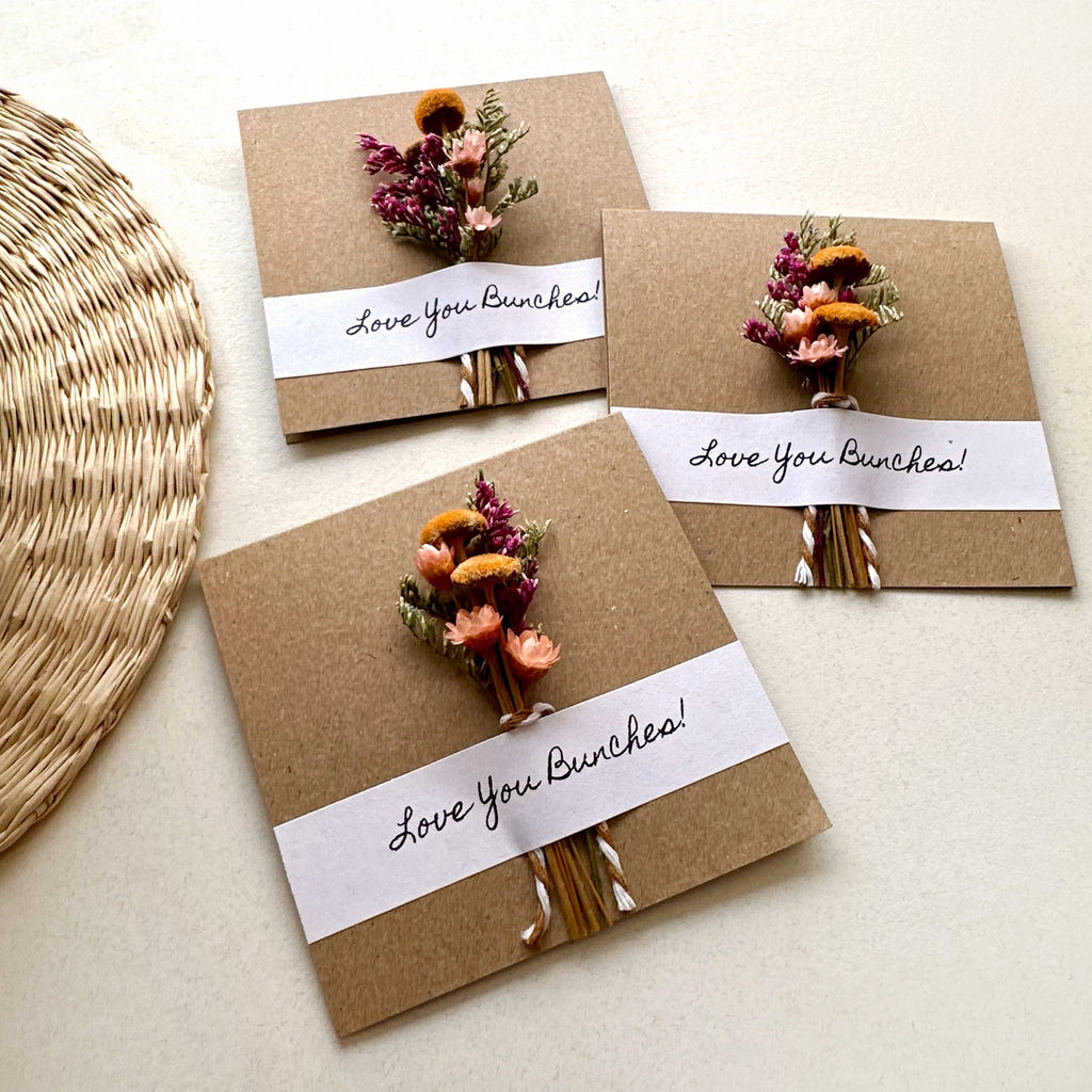 Three brown paper cards with dried flower bouquets and 'Love You Bunches!' text on a light background.