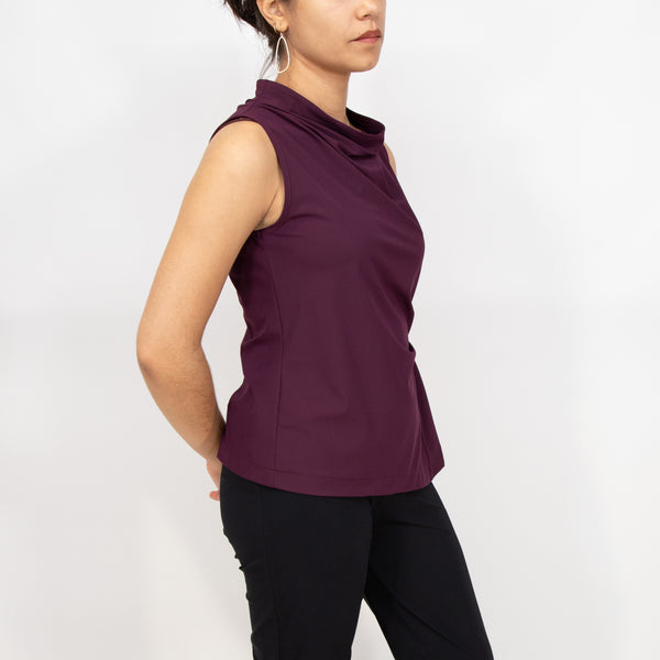 Woman wearing a sleeveless purple top against a white background