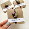 Three brown paper cards with floral decorations and 'thanks a Bunch!' text, held by a hand.