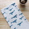 Kitchen towel with whale pattern on a wooden surface