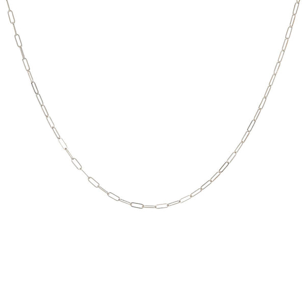 A delicate sterling silver layering necklace chain laid out on a plain background.